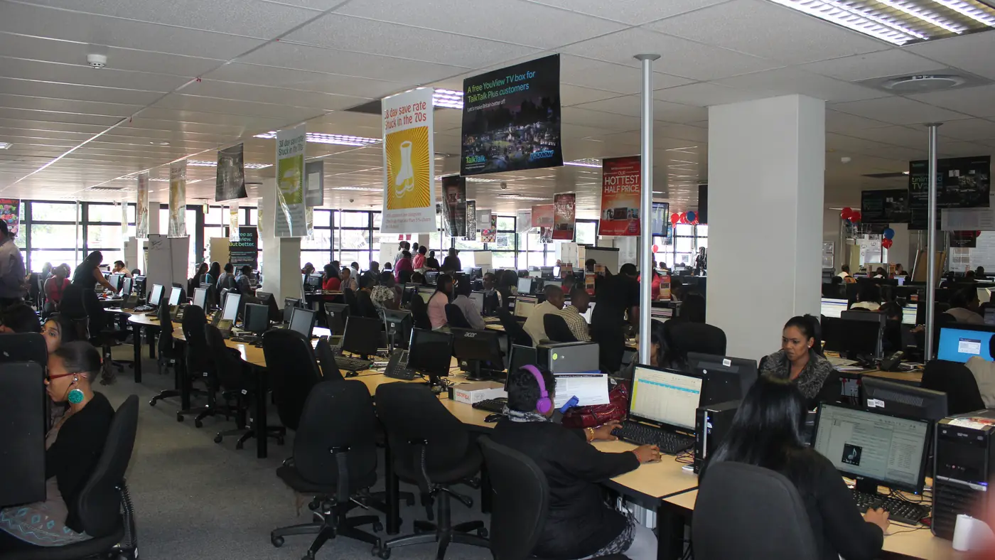 Photo: Singhira, CC BY-SA 4.0 A large office floor with rows of support staff working at computers
